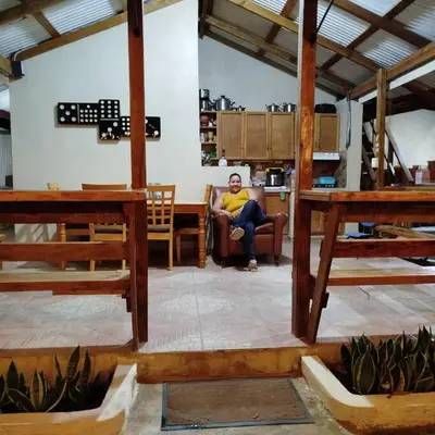 a woman sitting in a chair in a room at Estancia La Esperanza in Jarabacoa