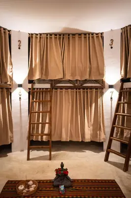 a bedroom with two bunk beds with curtains at Leisy's Garden Hostel & Rooms in Santa Bárbara de Samaná