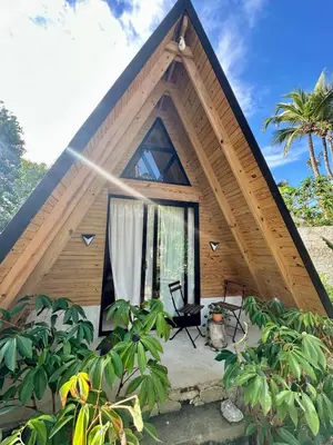 a house with a triangular roof with a patio at Leisy's Garden Hostel & Rooms in Santa Bárbara de Samaná
