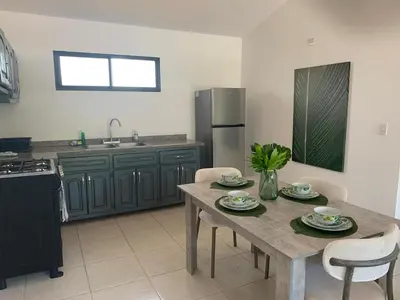 a kitchen with a table and chairs and a refrigerator at Jungle Oasis by the Beach in San Felipe de Puerto Plata