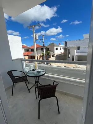 a table and chairs on a balcony with a view of a street at CGM BLUE 1hab in Bayahibe