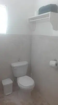 a white bathroom with a toilet and a window at Bayahibe Guest House Hotel in Bayahibe