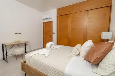 a bedroom with a bed with towel animals on it at Elegant 2 Bedroom Apartment with Pool in La Laguna