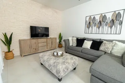 a living room with a couch and a flat screen tv at Elegant 2 Bedroom Apartment with Pool in La Laguna