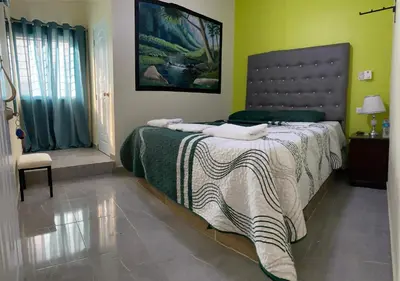 a bedroom with a large bed in a room at Hotel El Parque Constanza in Constanza
