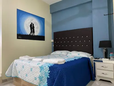 a bedroom with a bed with a picture on the wall at Hotel El Parque Constanza in Constanza