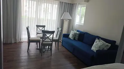 a living room with a blue couch and a table and chairs at Cadaques Caribe Palmera 101 in Bayahibe