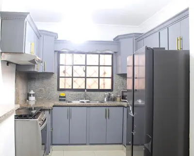 a blue kitchen with a sink and a refrigerator at Casa familiar con piscina y cerca de la playa in La Belleza