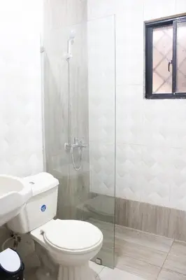 a bathroom with a toilet and a glass shower at Casa familiar con piscina y cerca de la playa in La Belleza