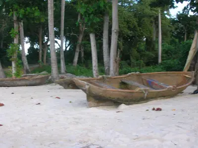 an old boat sitting on the sand on the beach at Casa Por Que No in Las Galeras