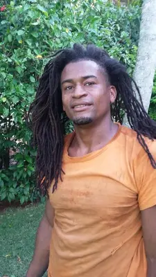a man with long dreadlocks standing in front of a tree at Casa Por Que No in Las Galeras