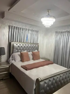 a bedroom with a bed with a silver headboard and curtains at Con in Santo Domingo