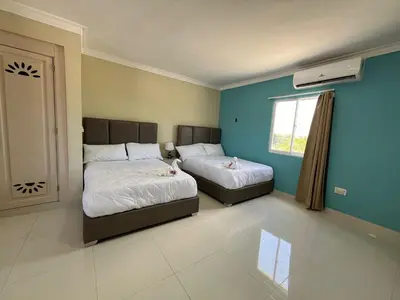 a bedroom with two beds and a window at Hotel El Imperio Punta Cana in Punta Cana