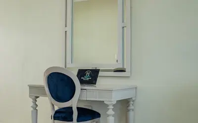 a desk with a blue chair and a mirror at Hotel El Imperio Punta Cana in Punta Cana