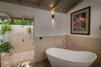 a bathroom with a white tub and a window at Villa Laguna, Lush Oasis In Casa De Campo in La Romana
