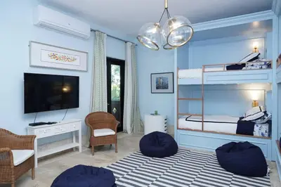 a blue room with a bunk bed with a television at Villa Alpes, Exquisite Retreat In Casa De Campo in La Romana
