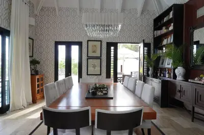 a dining room with a table and white chairs at Villa Alpes, Exquisite Retreat In Casa De Campo in La Romana