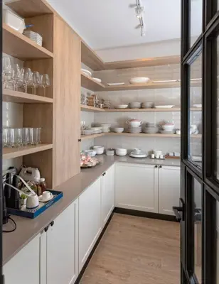 a kitchen with white cabinets and shelves with dishes at Villa Polos, Prestigious Haven In Casa De Campo in La Romana