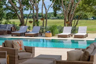 a pool with chaise lounge chairs and a swimming pool at Villa Polos, Prestigious Haven In Casa De Campo in La Romana