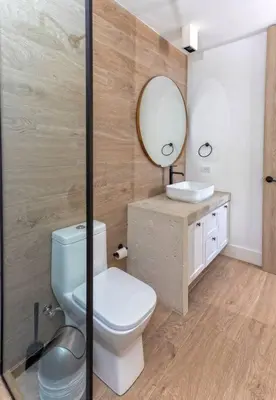 a bathroom with a toilet and a mirror at Villa Polos, Prestigious Haven In Casa De Campo in La Romana