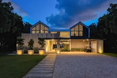 a house with a lit up driveway in front of it at Villa Polos, Prestigious Haven In Casa De Campo in La Romana