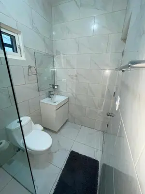 a white bathroom with a toilet and a shower at Level suites #2 platinum in Sosúa