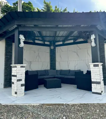 a pergola with a couch on a patio at Level suites #2 platinum in Sosúa