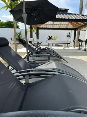 a group of chairs and a table with an umbrella at Level suites #2 platinum in Sosúa