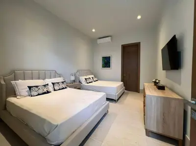 a bedroom with two beds and a flat screen tv at Villa Pradera, Upscale Comfort In Casa De Campo in La Romana