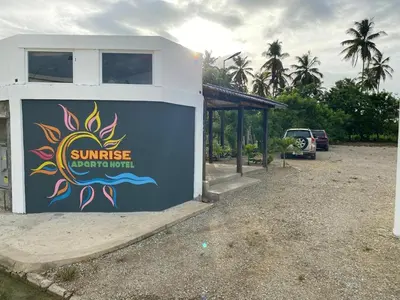 a building with a sign on the side of it at Sunrise ApartaHotel in El Manguito