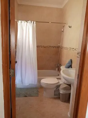 a bathroom with a toilet and a tub and a sink at Central Oasis Work or Explore the city in Santo Domingo