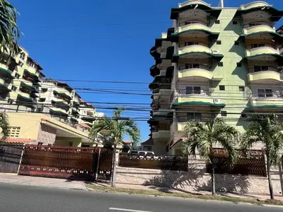 a tall building with palm trees in front of it at Central Oasis Work or Explore the city in Santo Domingo