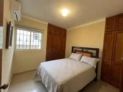 a bedroom with a bed and a window at Central Oasis Work or Explore the city in Santo Domingo