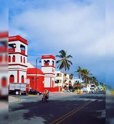a person riding a motorcycle down a street next to buildings at Tropical Estudio En El Centro De La Ciudad in San Felipe de Puerto Plata