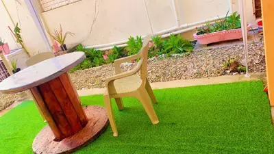 a patio with a table and chairs on green grass at Tropical Estudio En El Centro De La Ciudad in San Felipe de Puerto Plata