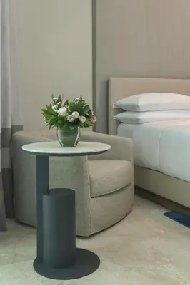 a table with a vase of flowers on it next to a bed at Hyatt Centric Santo Domingo in Santo Domingo