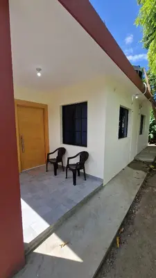 two benches sitting on the outside of a house at Mi Refugio in San Fernando de Monte Cristi