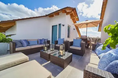 a patio with couches and chairs and an umbrella at New loft duplex with rooftop deck in La Laguna