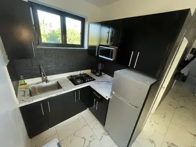 a small kitchen with a sink and a refrigerator at LEVEL suites #4 OMEGA in Sosúa