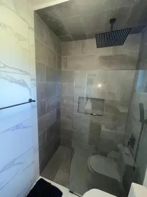a bathroom with a shower with a toilet at LEVEL suites #4 OMEGA in Sosúa