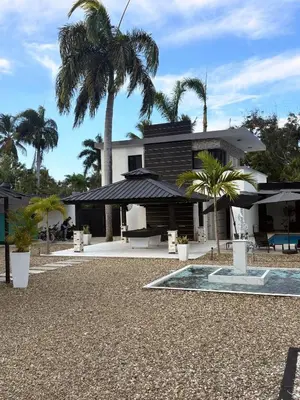 a house with a palm tree in front of it at LEVEL suites #4 OMEGA in Sosúa
