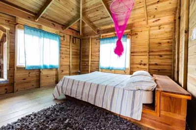 a bedroom with a bed in a wooden room at Mango House Big air studio in Cabarete