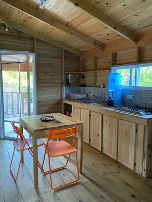a kitchen with a table and chairs in a cabin at Mango House Big air studio in Cabarete