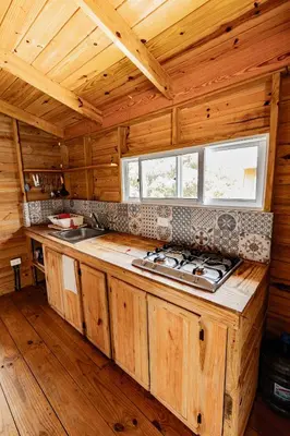 a kitchen with a stove top in a wooden cabin at Mango House Big air studio in Cabarete