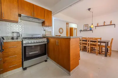 a kitchen with a stove and a dining room at la maguana - cozy and beautiful 3BR home with pool in Santiago de los Caballeros