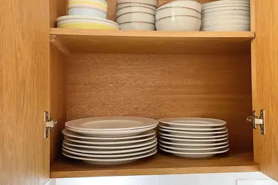 a cabinet filled with plates and bowls at la maguana - cozy and beautiful 3BR home with pool in Santiago de los Caballeros