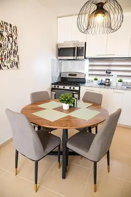 a kitchen with a wooden table with chairs and a stove at Europeo tropical in La Javilla