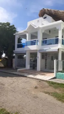 a white house with a fence in front of it at La casa de Marcel et Nathalie in Baní