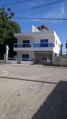 a white house with a garage in front of it at La casa de Marcel et Nathalie in Baní