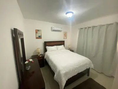 a bedroom with a bed with white sheets and a window at Apartamento completo en Bayahibe in Bayahibe